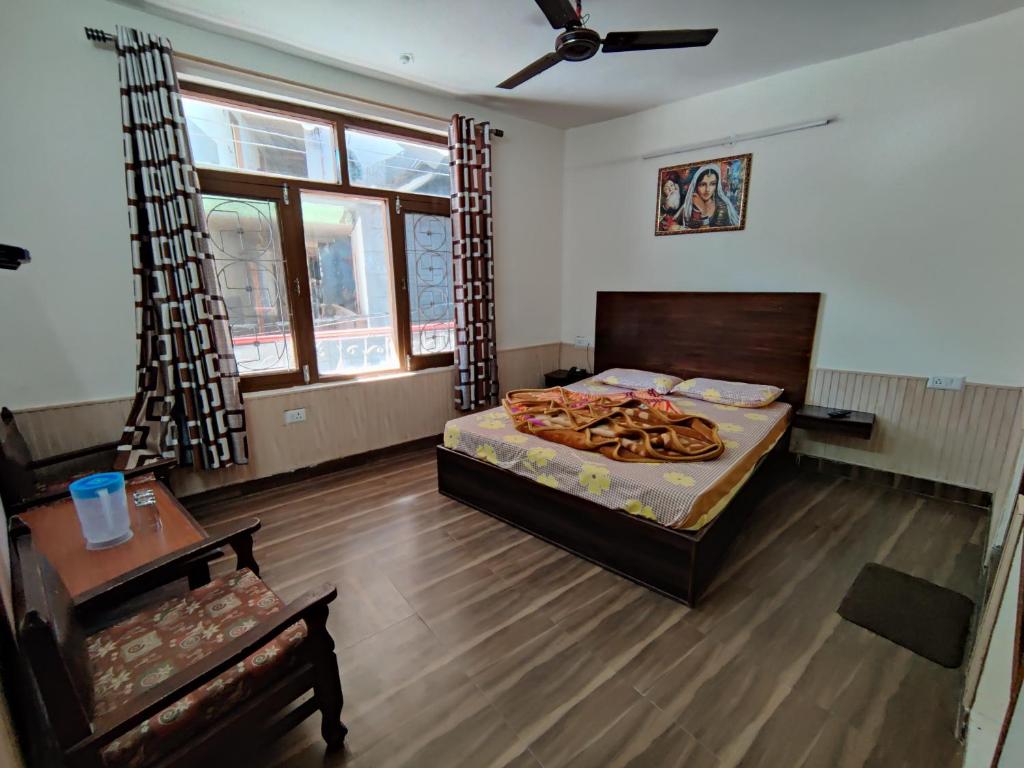 a bedroom with a bed and a table and a couch at Hotel Alankar in Manāli