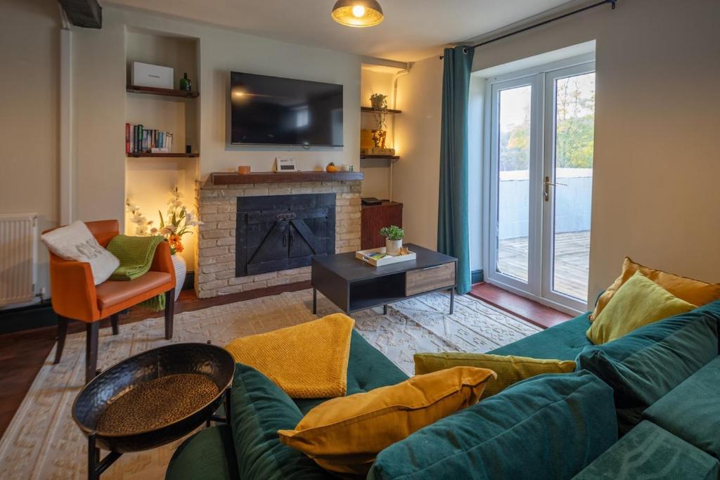 a living room with a couch and a fireplace at Cottage style with lovely mountain views in Moffat