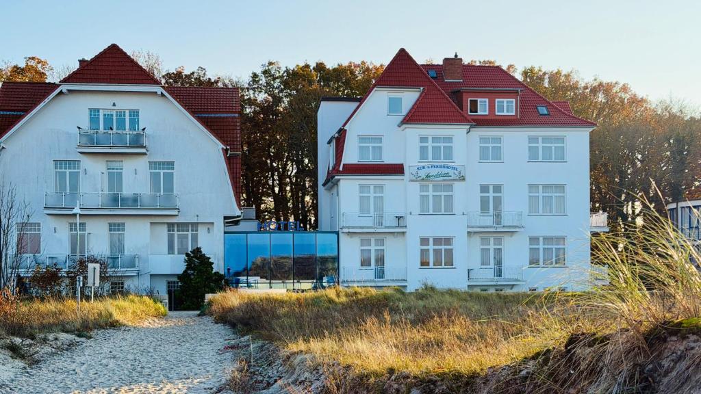 a large white house with a red roof at "Sanddorn", Kur- und Ferienhotel, Direkte Strandlage, Fahrstuhl in Warnemünde