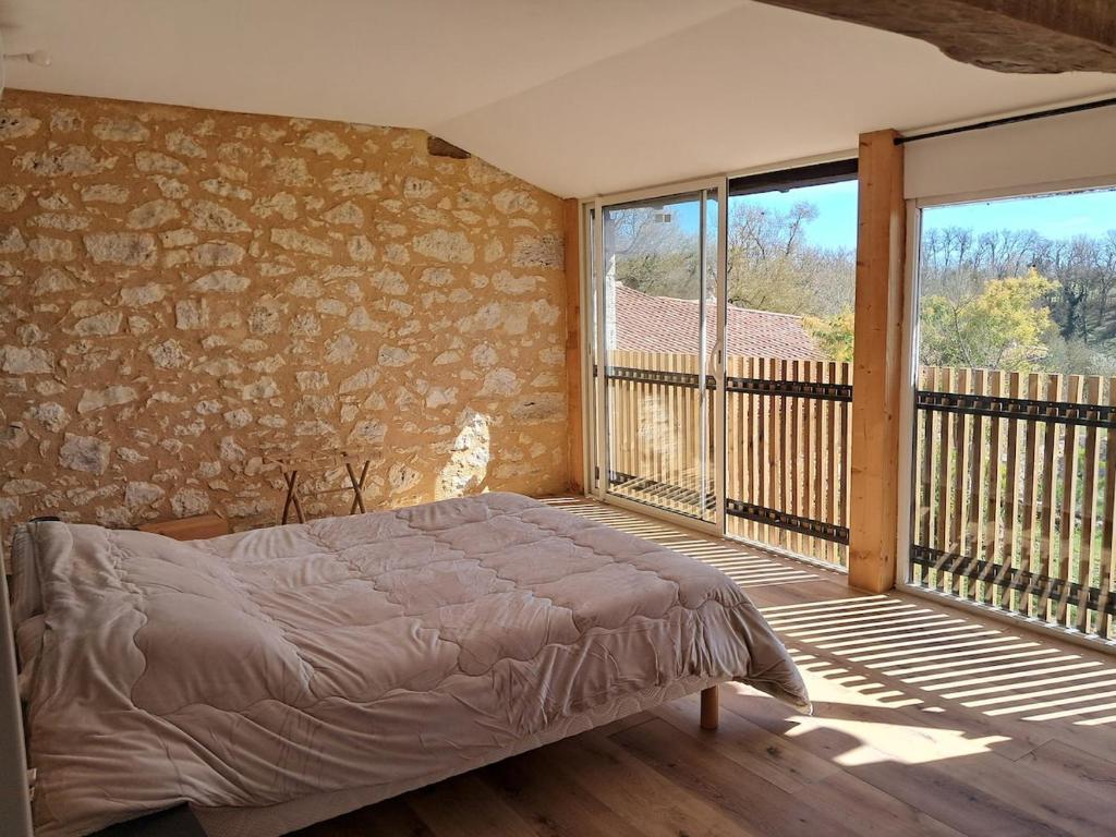 una camera con letto su un balcone di Gîte En Gélion a Sarrant