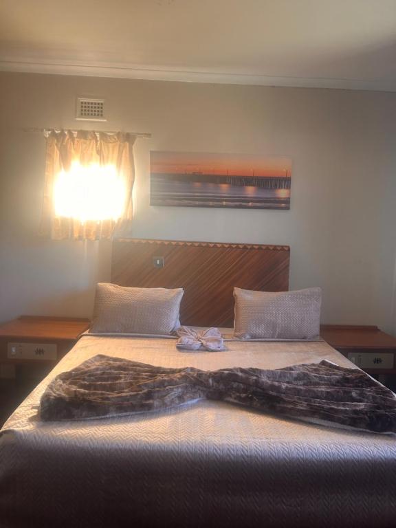 a bedroom with a bed with a blanket on it at Nathi Lodge in New Germany