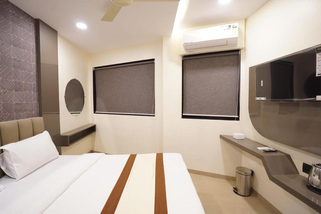 une chambre d'hôtel avec un lit et une télévision dans l'établissement Hotel Akasa Residency Near T-2 International Airport Mumbai, à Mumbai
