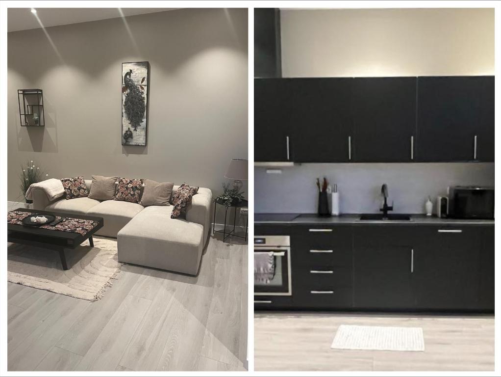 a living room with a couch and a kitchen at Delikat, romslig og sjønær sentrumsleilighet in Larvik