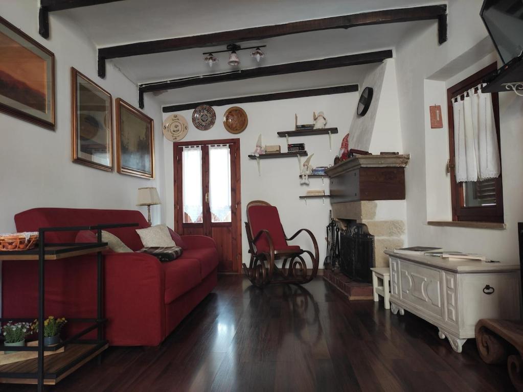a living room with a red couch and a fireplace at Casina Giulia in Capistrello