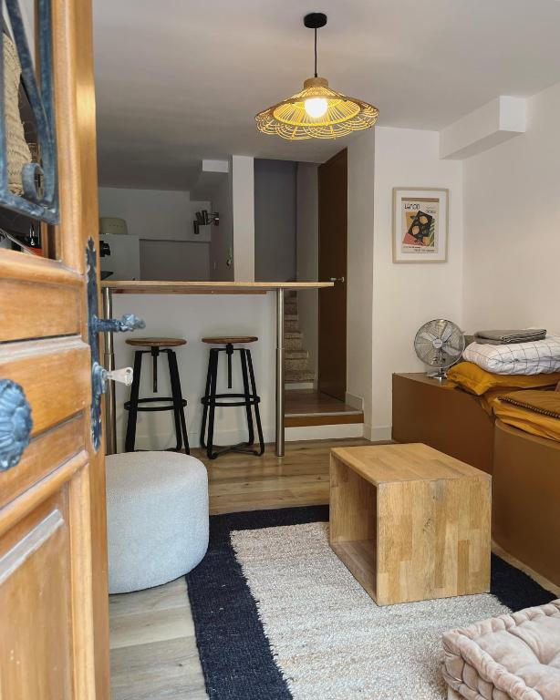 a living room with a kitchen and a bar at Maison Émile - Petit cocon au cœur du village in Leucate