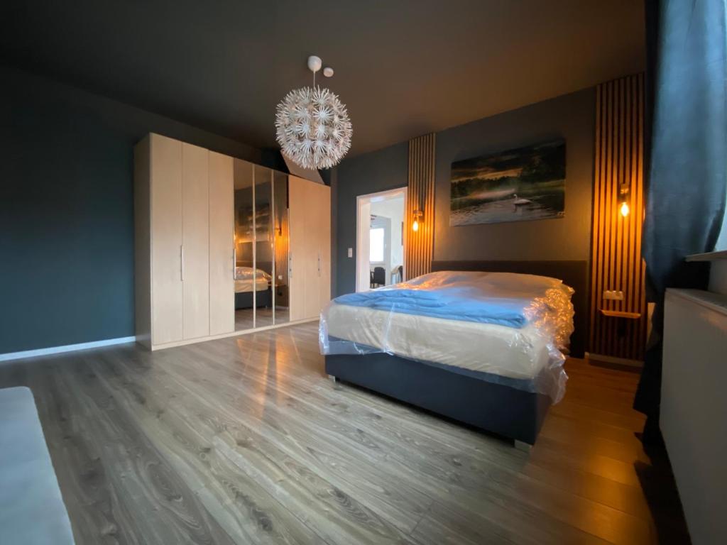 a bedroom with a bed and a chandelier at Atelier 1a in Cottbus