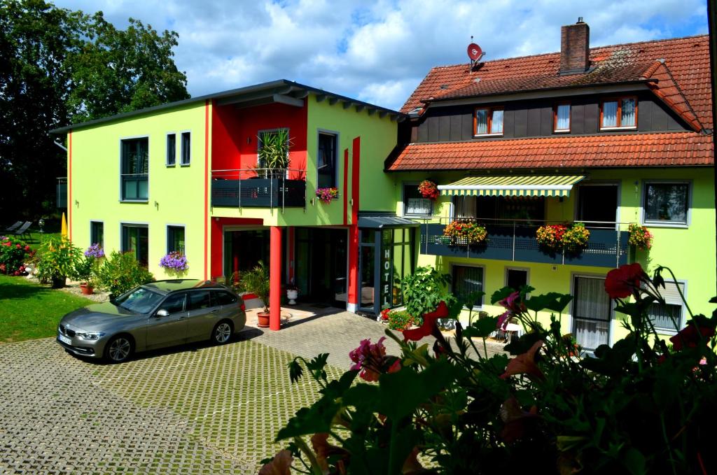 a car parked in front of a house at ROTHSEE Hotel in Allersberg