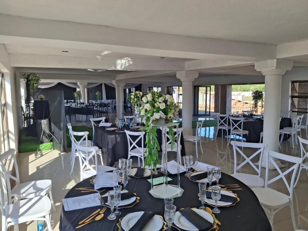 a dining room with tables and chairs and flowers at The Private Location in Thohoyandou