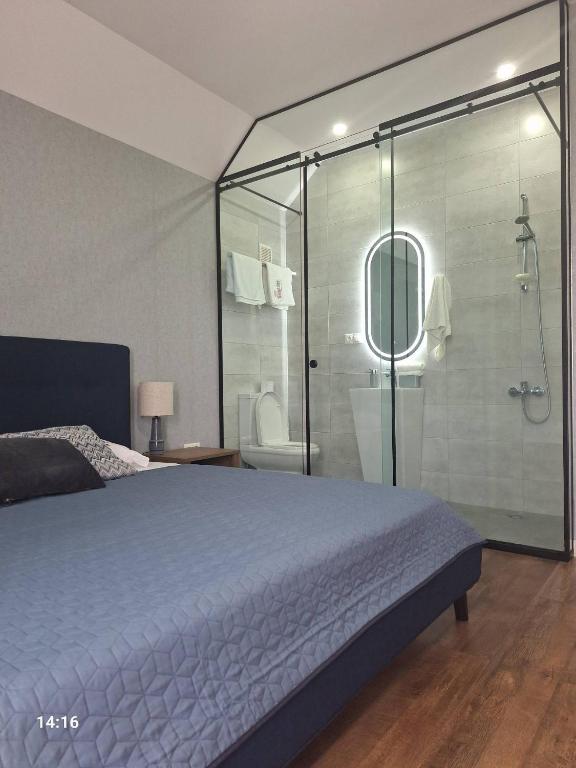 a bedroom with a bed and a glass shower at Tsitadel in Zugdidi
