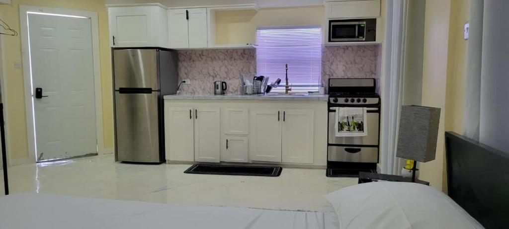 a kitchen with white cabinets and stainless steel appliances at Lovely 2 bedroom in the city in Saint Georgeʼs