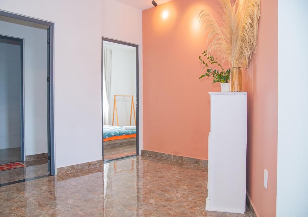 a hallway with a mirror and a vase with a plant at Vanille De House in Xuan An