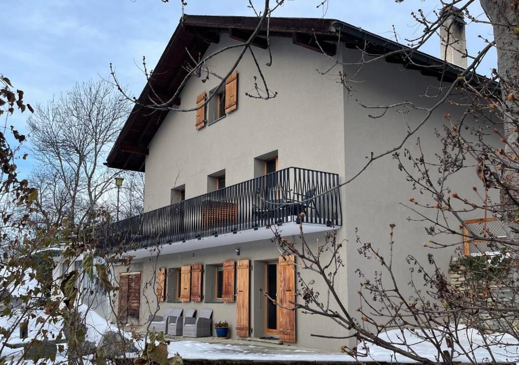 a white house with a balcony on the side of it at B&B La Forge de Diogne - luxury and cosy alpine lodge in Crans-Montana
