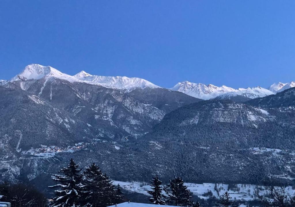 a view of a mountain range with snow covered mountains at La Forge de Diogne - luxury and cosy B&B Alpine lodge in Crans-Montana