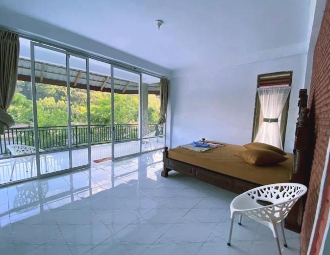 een slaapkamer met een bed en een balkon bij Tiga dara guest house jungle trekking in Bukit Lawang
