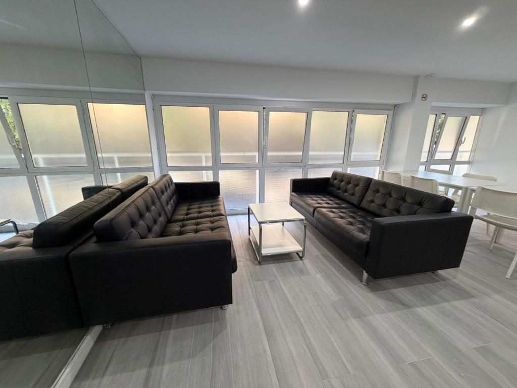 a living room with two couches and a table at Hostel Hock Residences in Hospitalet de Llobregat