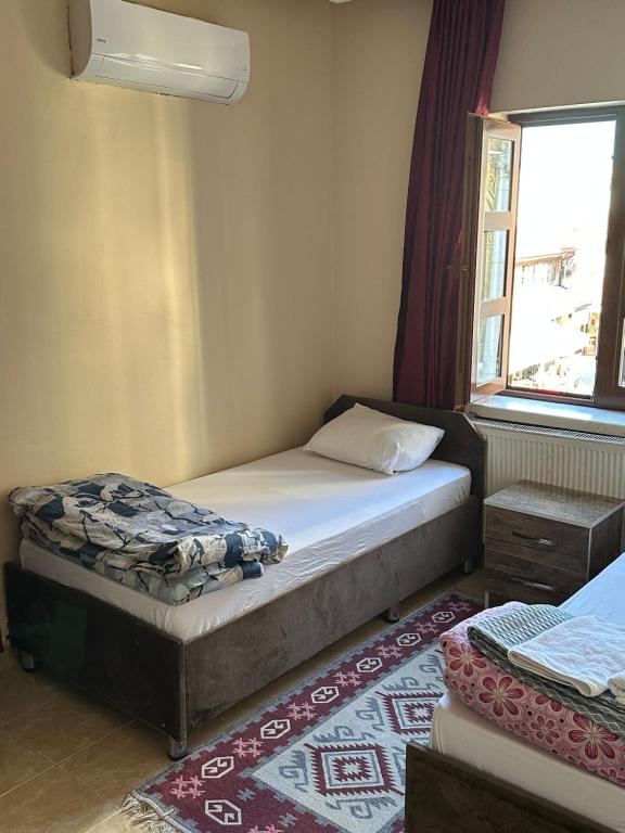 a small bedroom with a bed and a window at ESER PALAS OTELİ in Konya