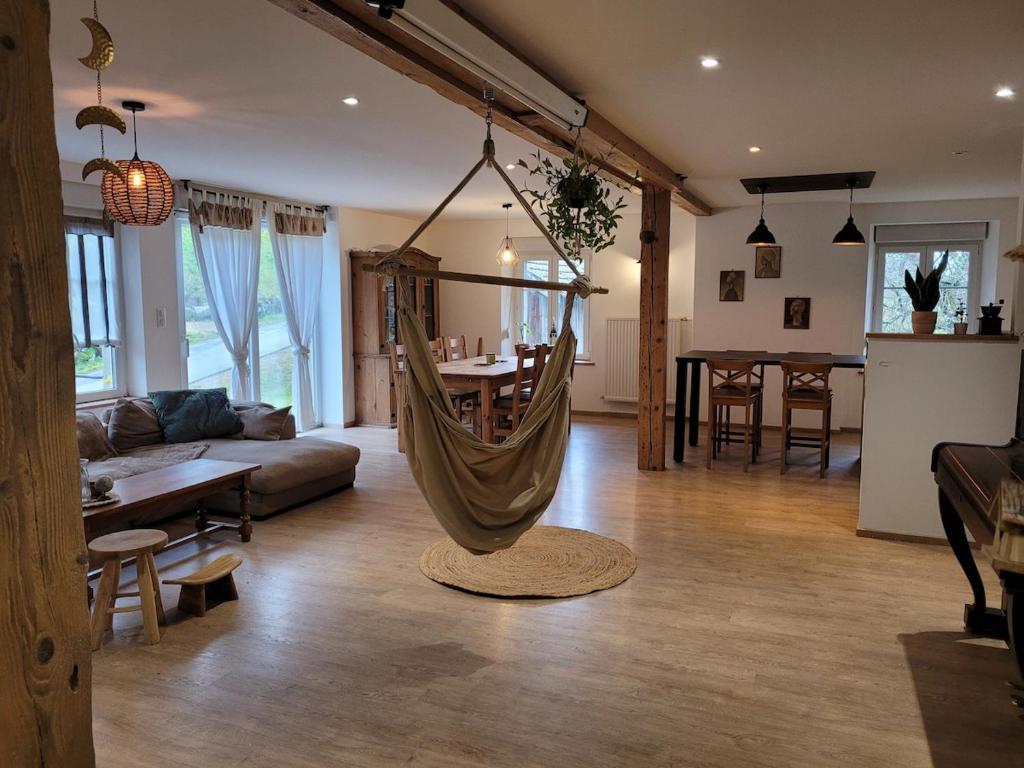 a living room with a hammock in the middle at Gîte cosy dans les Vosges in Rochesson