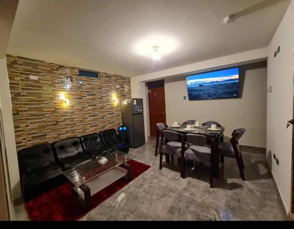 a living room with a table and a black couch at Departamento en Nuevo Chimbote in Chimbote
