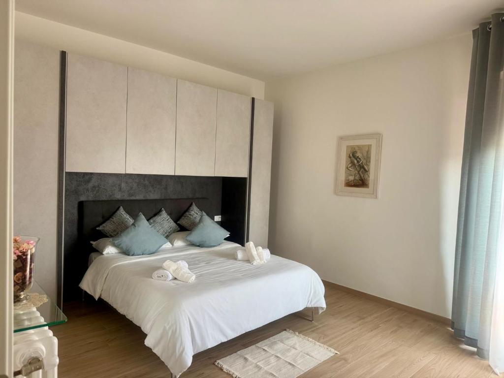 a bedroom with a large white bed with blue pillows at Casa La Perla in Montevarchi