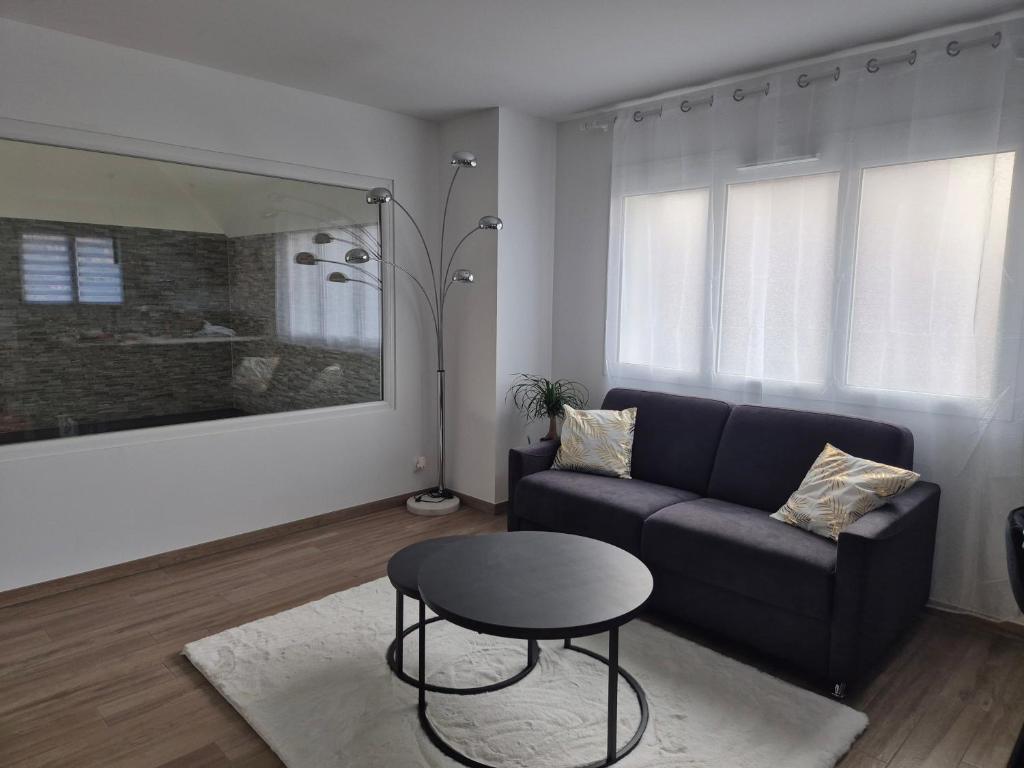 una sala de estar con un sofá y una mesa en Gîte Un instant de rêve à Dorlisheim, piscine intérieure chauffée, sauna, en Dorlisheim