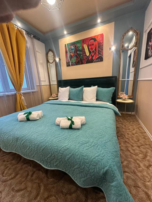 a bedroom with a large bed with towels on it at Courtyard Central Premium Apartment in Craiova