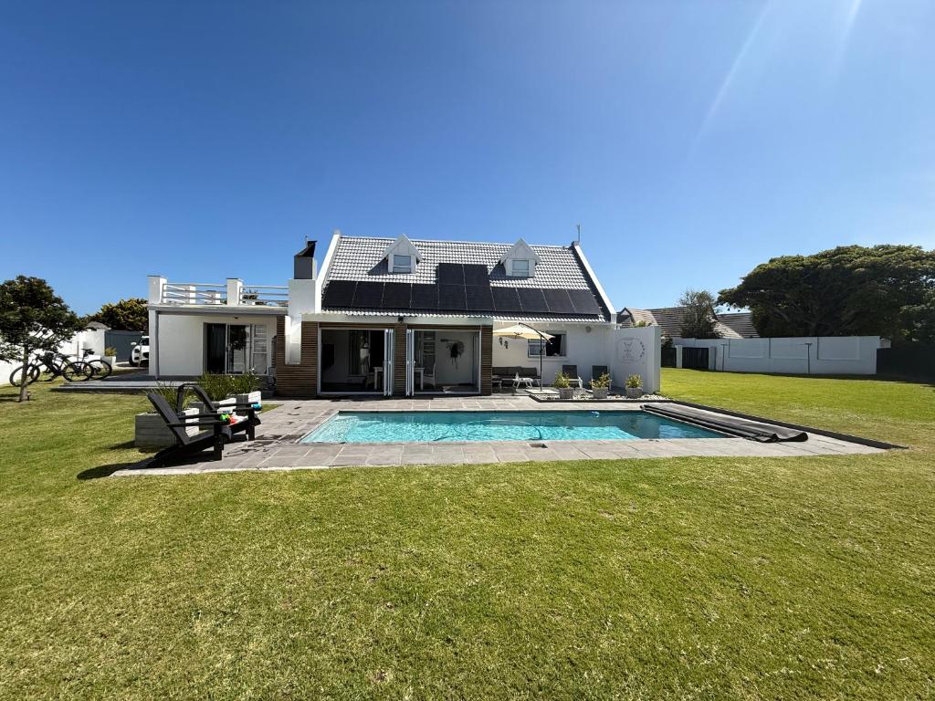 a house with a swimming pool in the yard at THE SURF AND GOLF HUIS Solar Power in St Francis Bay