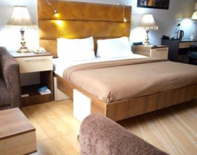 une chambre d'hôtel avec un lit et une chaise dans l'établissement Li Tour International Hotel, à Ikeja