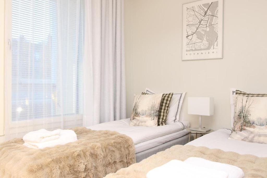 a white room with two beds and a couch at Arctic Willamo Studio- Rovaniemi in Rovaniemi