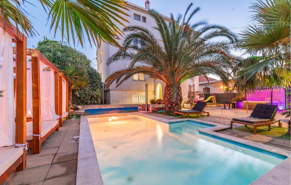 a swimming pool in the backyard of a house at Cozy Apartment In Sukosan in Sukošan