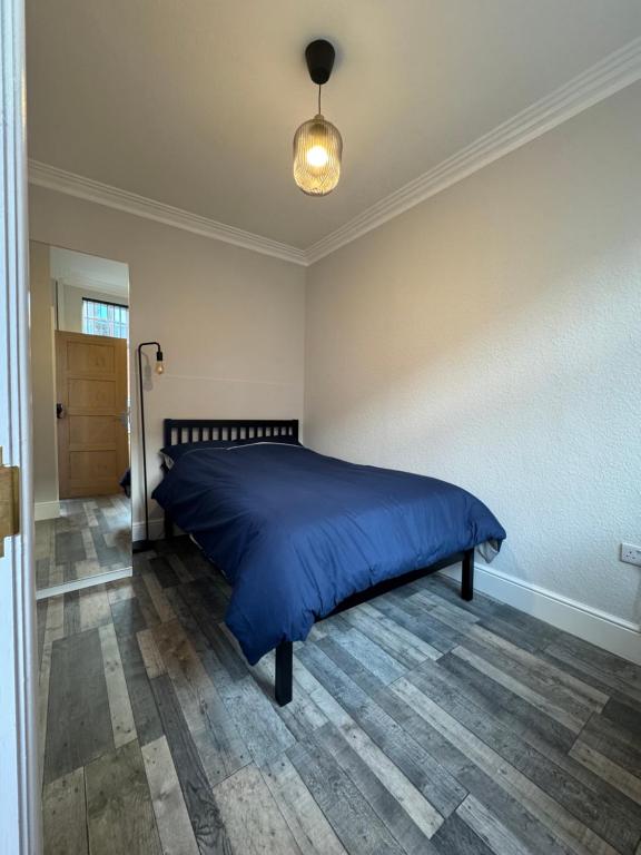 a bedroom with a bed with a blue comforter at Serenity LTD in Leicester