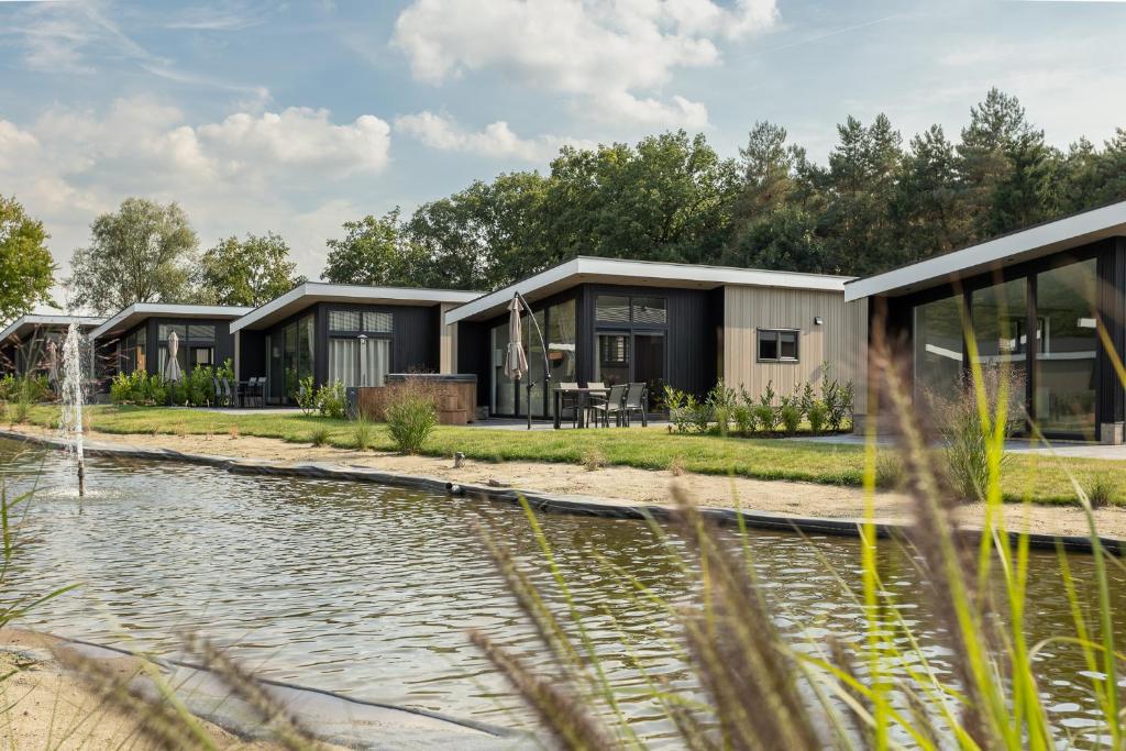 a row of modular homes next to a pond at Residence Winterswijk in Winterswijk