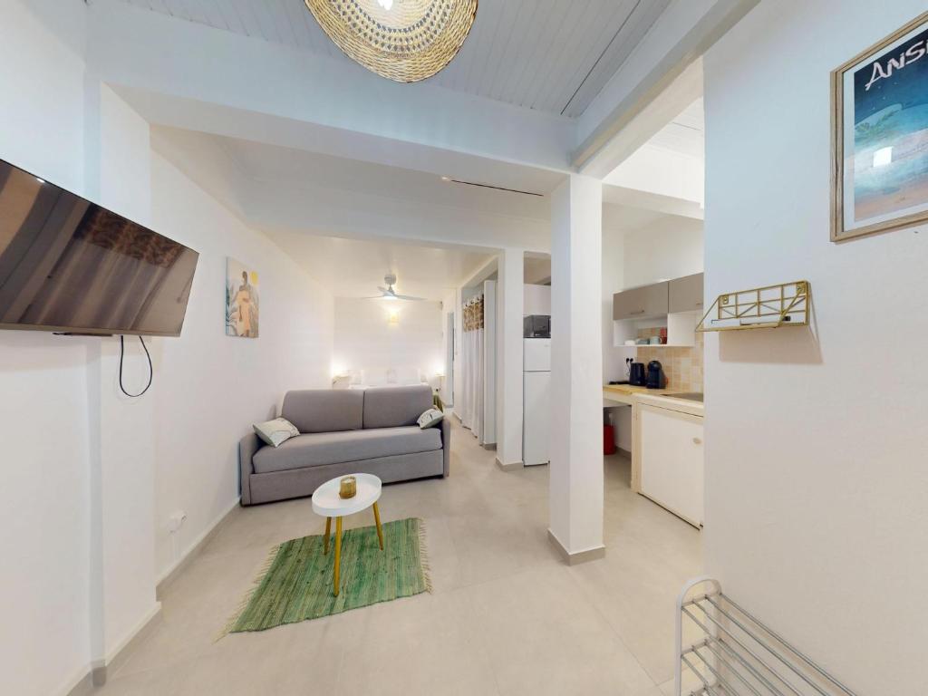 a living room with a couch and a table at Anoli Studio Location in Les Trois-Îlets