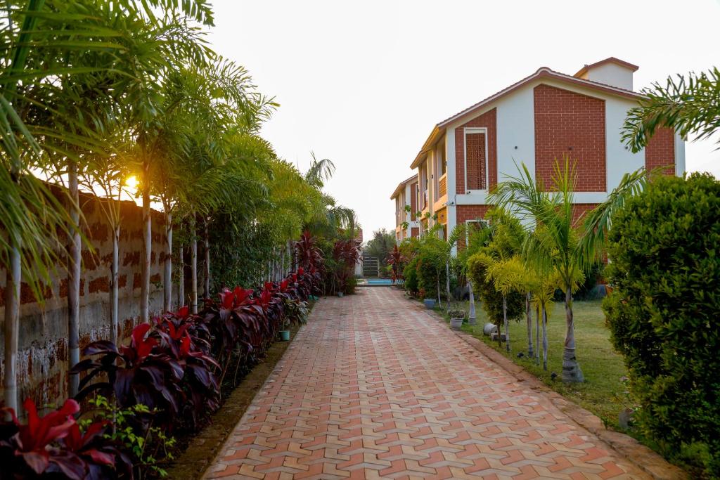 Un camino de ladrillos con plantas y un edificio. en Xylem Sea Side Resort, en Puri