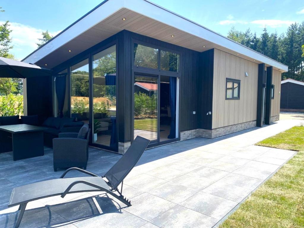 een huis met glazen deuren en een patio bij Hillenaar in Huppel