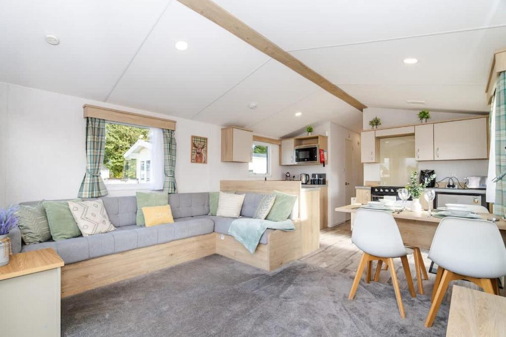 a living room with a couch and a kitchen at 3Bed Caravan - Muirfield in Port Seton