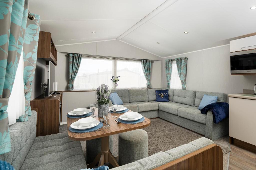 a living room with a couch and a table at Seton Sands-3 Bed Static Caravan in Port Seton