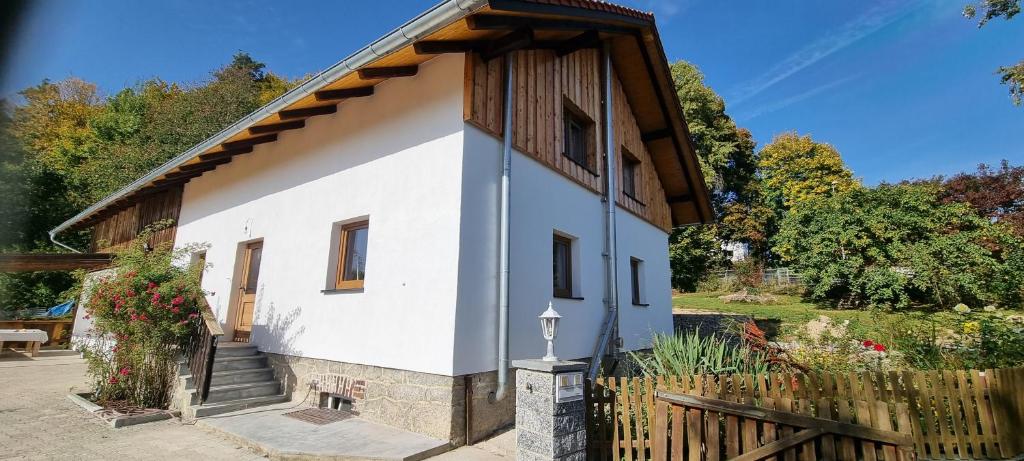 a small white house with a wooden fence at Time Out Moments Haus mit eigener Sauna in Grafenau