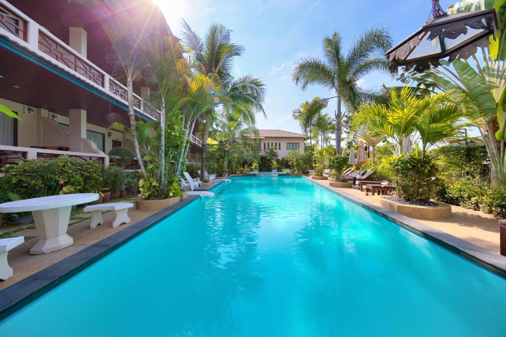 een zwembad in een resort met blauw water en palmbomen bij Aumpai Luxury in Lamai