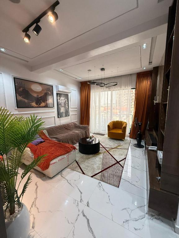 uma sala de estar com um sofá e uma mesa em Palm & Pearl Apartment em Lekki