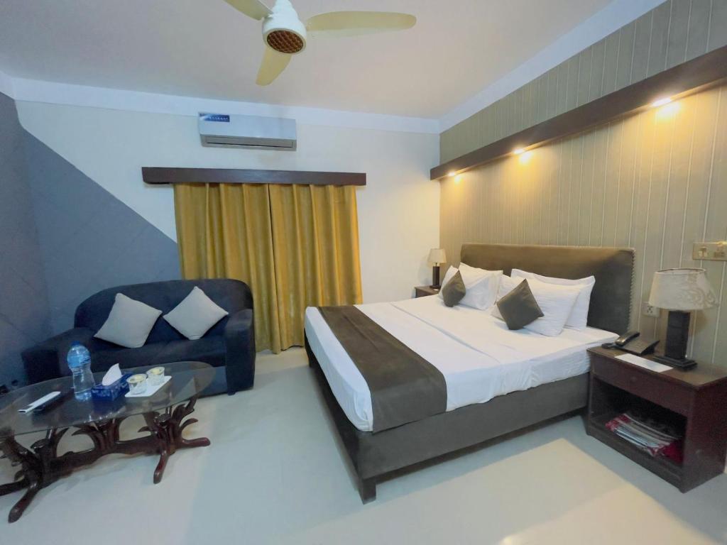 a hotel room with a bed and a chair at Royal Ilva Hotel in Lahore