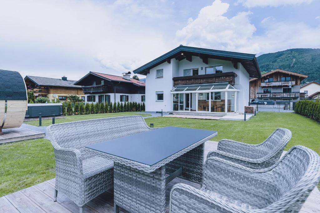 een terras met een tafel en stoelen voor een huis bij Spa Chalet by we rent in Zell am See