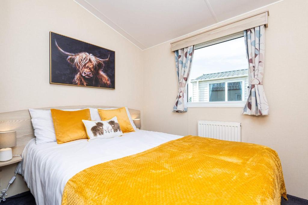 a bedroom with a bed and a window at 3Bedroom Caravan Seton Sands in Port Seton