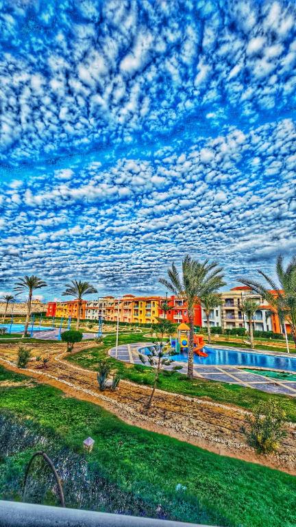 a view of a resort with a swimming pool and palm trees at Porto Matrouh Elabd Family in Marsa Matruh