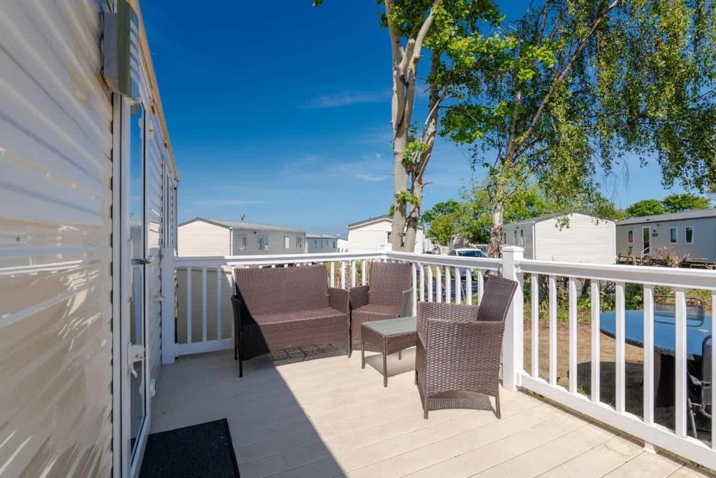 a balcony with two chairs and a table at 3 Bed Caravan - Seton Sands in Port Seton
