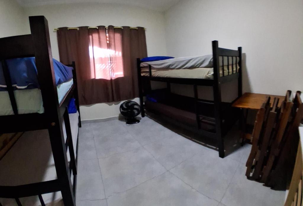 Habitación con 2 literas, mesa y ventana en Bela Mar Mongaguá, en Mongaguá
