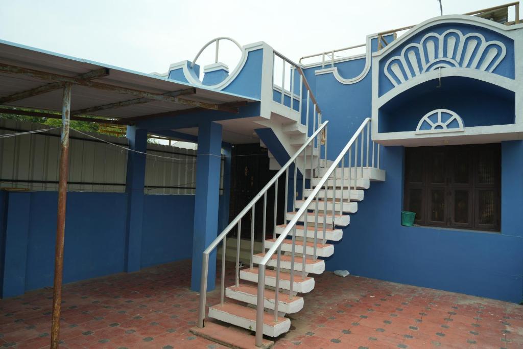 ein blaues Gebäude mit Treppen an der Seite in der Unterkunft MNP Home Stay in Rāmeswaram
