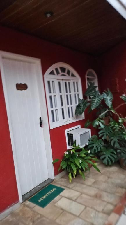 a room with a door and a plant in front of it at Pousada Pitória in São Pedro da Aldeia