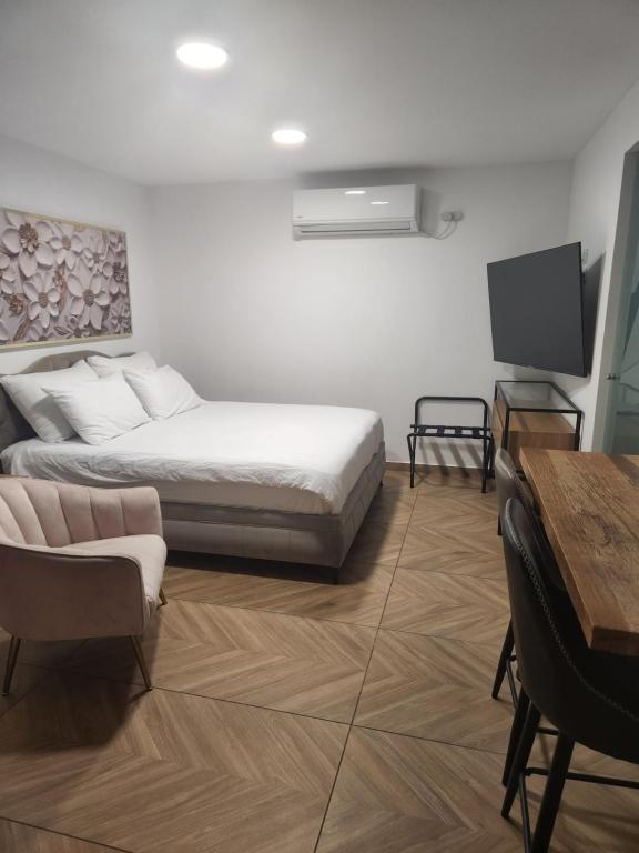 a bedroom with a bed and a tv and a table at יחידת סאן סנטר באילת in Eilat