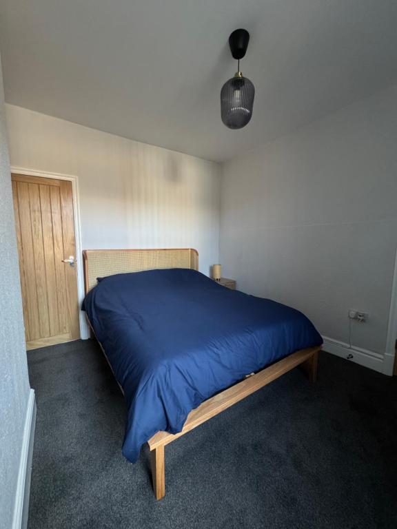 レスターにあるSerenity LTDの青い毛布が掛けられたベッドのある寝室