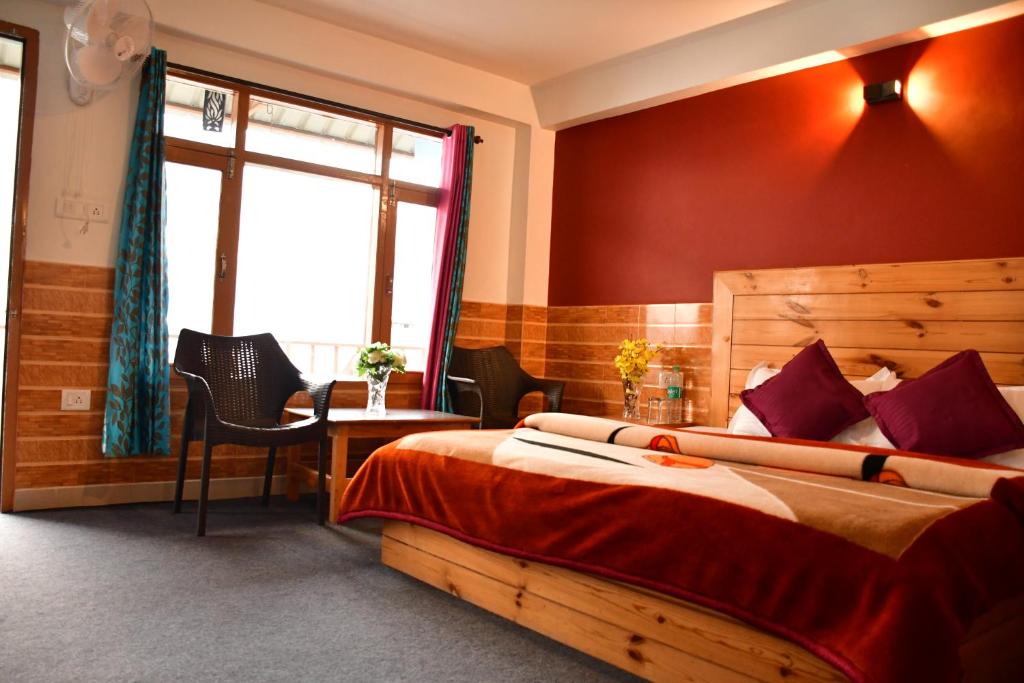 ein Schlafzimmer mit Bett, Schreibtisch und Fenster in der Unterkunft Guruchhaya hotel and cottages in Manali